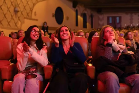 Trois spectatrices souriantes en train d'applaudir